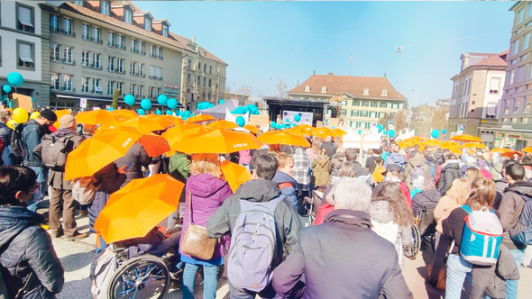 Menschenmenge auf dem Waisenhausplatz mit vielen orangen Procap Schirmen